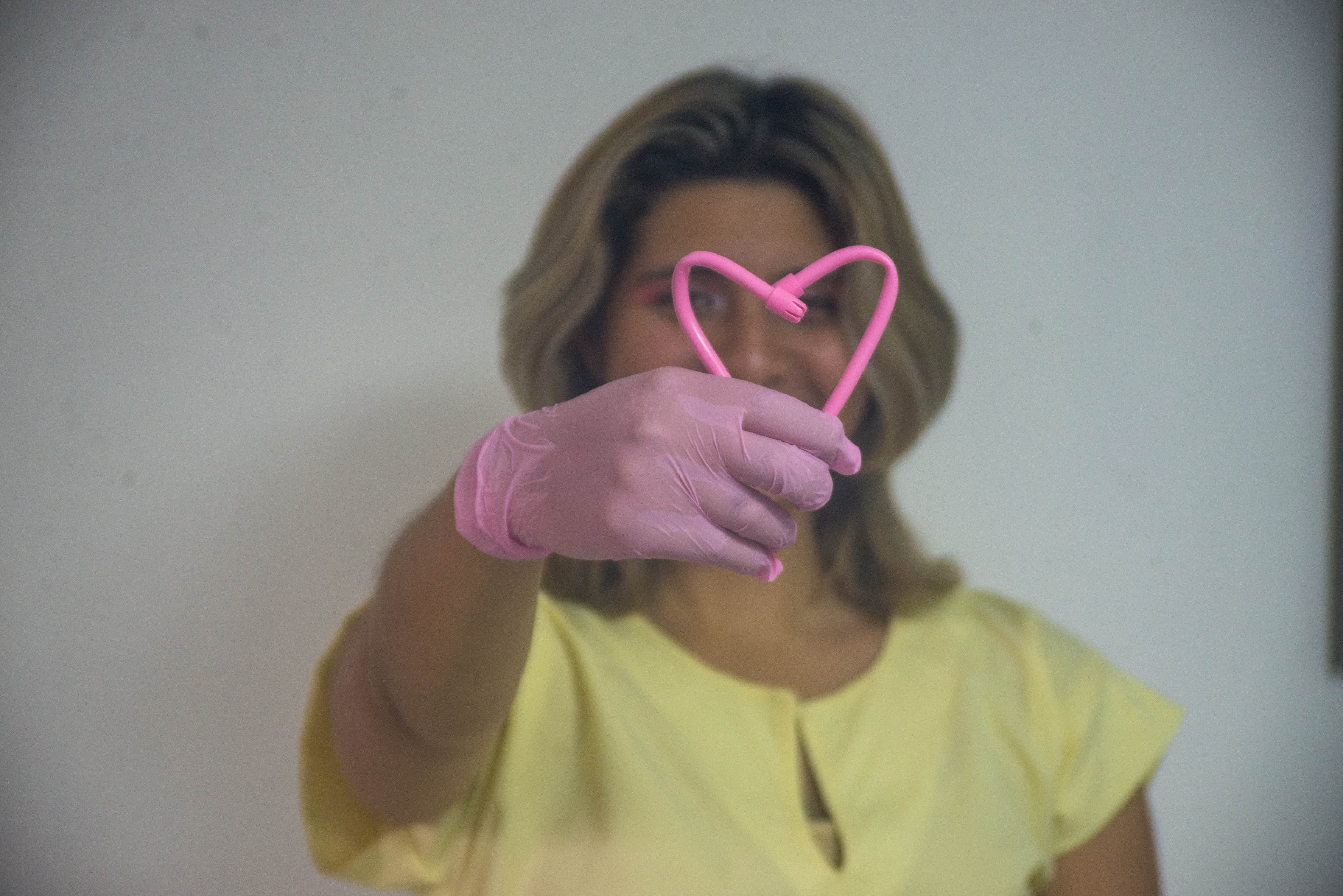 Profesional de la clínica formando un corazón con un instrumento dental